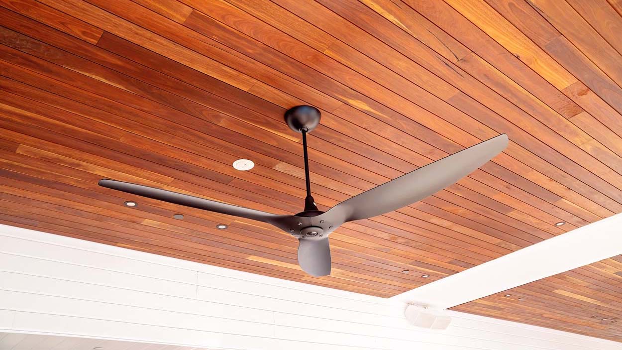 Overhead fan hanging from a timber ceiling to cool guests at a luxury resort hotel
