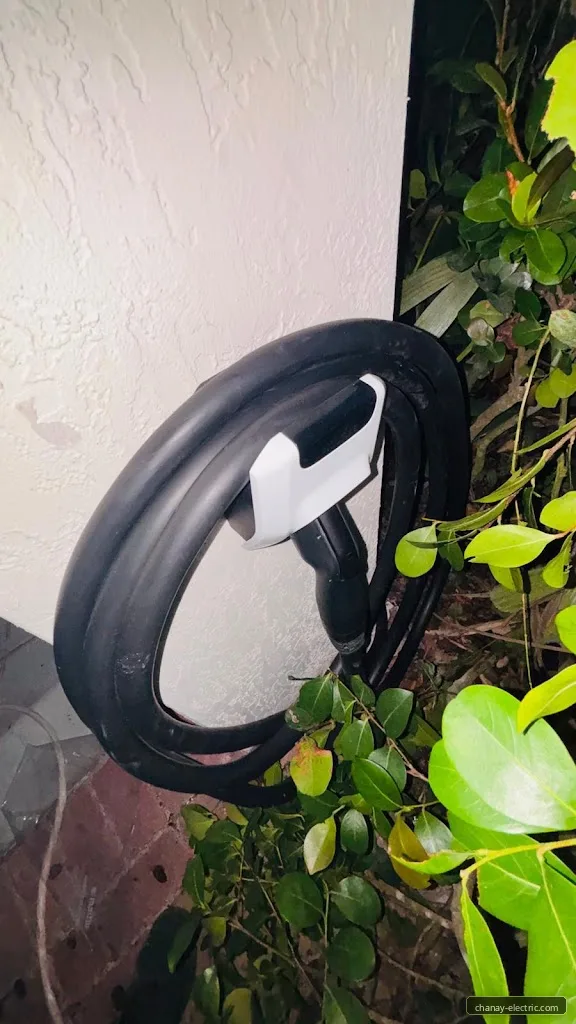 EV charging cable coiled beside an outdoor wall charger